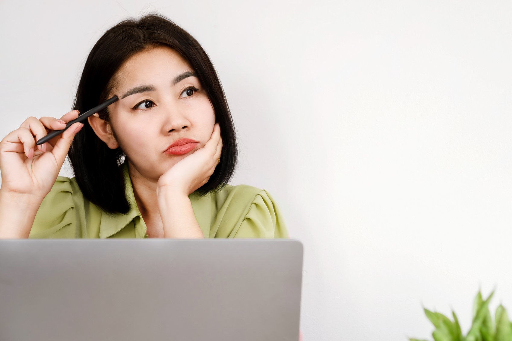 lack of inspiration Asian woman office worker sitting at desk with no motivation for work